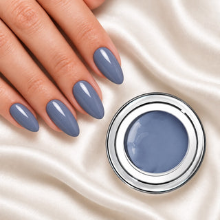Nageldesign in Tauben Blau Grau neben einem offenen Farbgel-Tiegel auf weißem Stoff