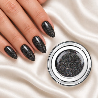 Nageldesign in Glam Schwarz neben einem offenen Farbgel-Tiegel auf weißem Stoff