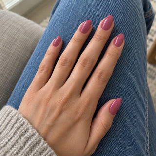 Nageldesign in Warmes Puder Nude – Hand mit lackierten Nägeln auf blauem Jeansstoff