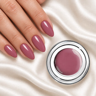 Nageldesign in Warmes Puder Nude neben einem offenen Farbgel-Tiegel auf weißem Stoff