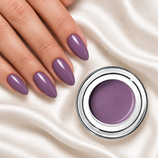Nageldesign in Kühles Nude Lila neben einem offenen Farbgel-Tiegel auf weißem Stoff