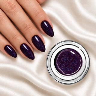 Nageldesign in Glam Galaxy Schwarz Violett neben einem offenen Farbgel-Tiegel auf weißem Stoff