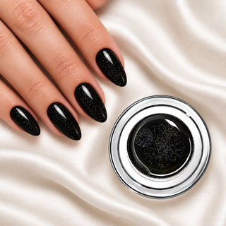 Nageldesign in Glam Diamant Schwarz neben einem offenen Farbgel-Tiegel auf weißem Stoff
