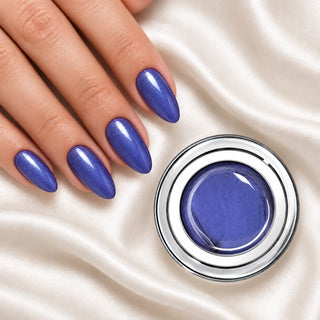 Nageldesign in Metallic Blau neben einem offenen Farbgel-Tiegel auf weißem Stoff
