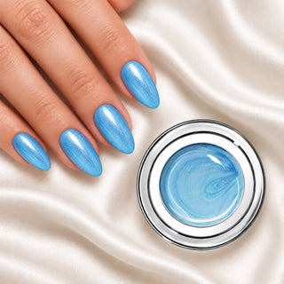Nageldesign in Metallic Himmels Blau neben einem offenen Farbgel-Tiegel auf weißem Stoff
