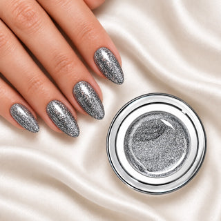 Nageldesign in Silber Glitzer Party neben einem offenen Farbgel-Tiegel auf weißem Stoff