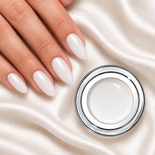 Nageldesign in Glimmer Candy Weiß neben einem offenen Farbgel-Tiegel auf weißem Stoff