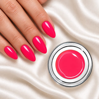 Nageldesign in Metallic Neon Barbie Pink neben einem offenen Farbgel-Tiegel auf weißem Stoff