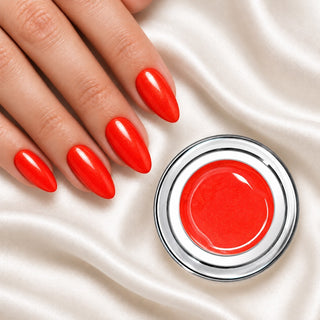 Nageldesign in Metallic Neon Rot Orange neben einem offenen Farbgel-Tiegel auf weißem Stoff