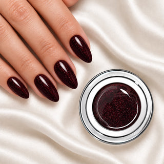 Nageldesign in Glimmer Wein Rot Dunkel neben einem Farbgel-Tiegel auf weißem Stoff