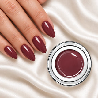 Nageldesign in Nude Berry neben einem offenen Farbgel-Tiegel auf weißem Stoff