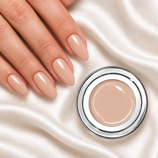 Nageldesign in Cremiges Light Nude neben einem offenen Farbgel-Tiegel auf weißem Stoff