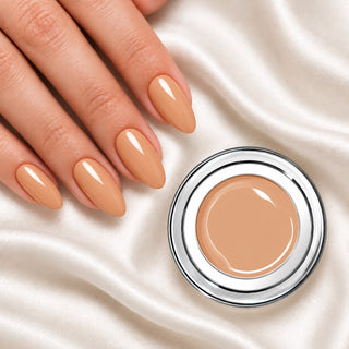 Nageldesign in Elegance Nude neben einem offenen Farbgel-Tiegel auf weißem Stoff