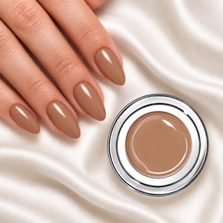 Nageldesign in Peanut Nude neben einem offenen Farbgel-Tiegel auf weißem Stoff