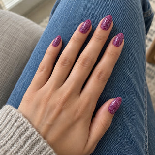 Nageldesign in Disco Bordeaux – Hand mit lackierten Nägeln auf blauem Jeansstoff