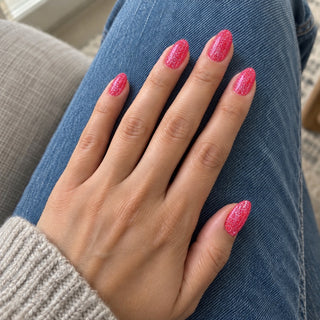 Nageldesign in Disco Knalliges Rot – Hand mit lackierten Nägeln auf blauem Jeansstoff
