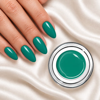 Nageldesign in Candy Türkis neben einem Farbgel-Tiegel auf weißem Stoff