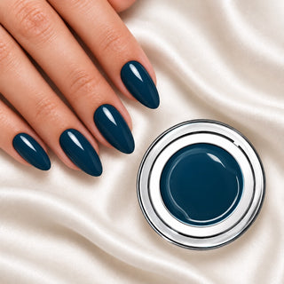Nageldesign in Klassisch Blau neben einem Farbgel-Tiegel auf weißem Stoff