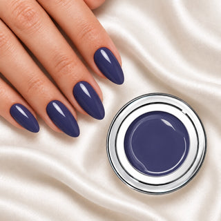 Nageldesign in Dunkles Nacht Blau neben einem Farbgel-Tiegel auf weißem Stoff