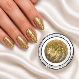 Nageldesign in Glamour Gold neben einem Farbgel-Tiegel auf weißem Stoff