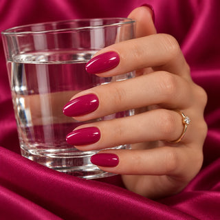 Hand mit langen Nägeln in Magenta und verschiedenen Lilatönen, darunter Happy Magenta 90004 von Rockstar Nails.