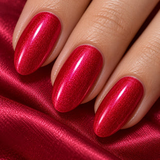 Nahaufnahme mandelförmiger Nägel mit lila-rotem Metallic-Schimmer auf rotem Satin – Rockstar Nails Gellack 90012.