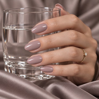 Hand mit taupefarbenen Nägeln hält ein Wasserglas – Rockstar Nails Gellack 90021 Warmes Taupe.