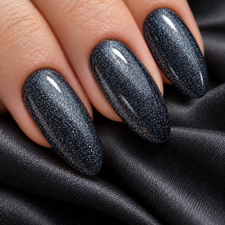 Nahaufnahme mandelförmiger schwarzer Nägel mit feinen silbrig-blauen Glitzerreflexen – Rockstar Nails Gellack 90024.