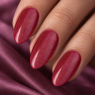 Nahaufnahme mandelförmiger Nägel mit feinem violett-rotem Glitzer auf Satin – Rockstar Nails Gellack 90013.